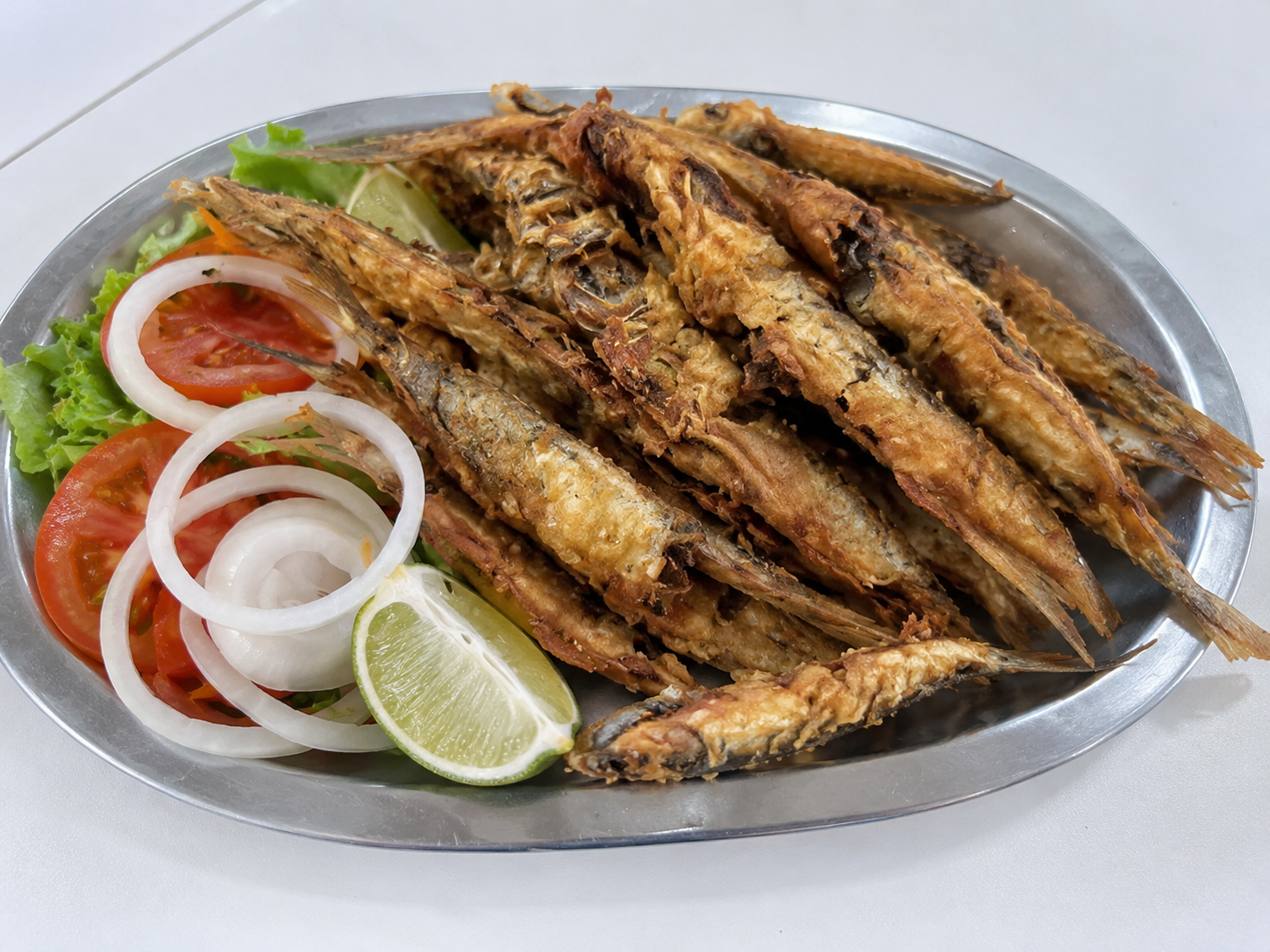 Peixe frito com salada e limão